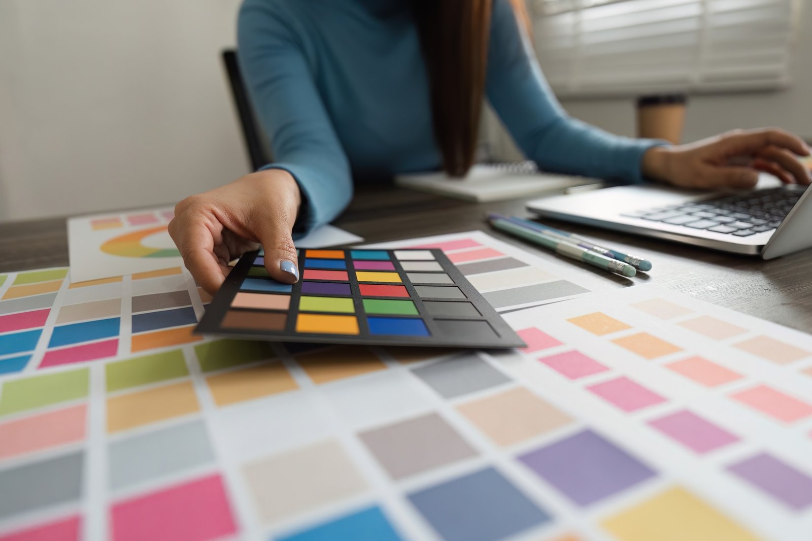 A professional designer evaluating color options using swatches in a stylish workspace.