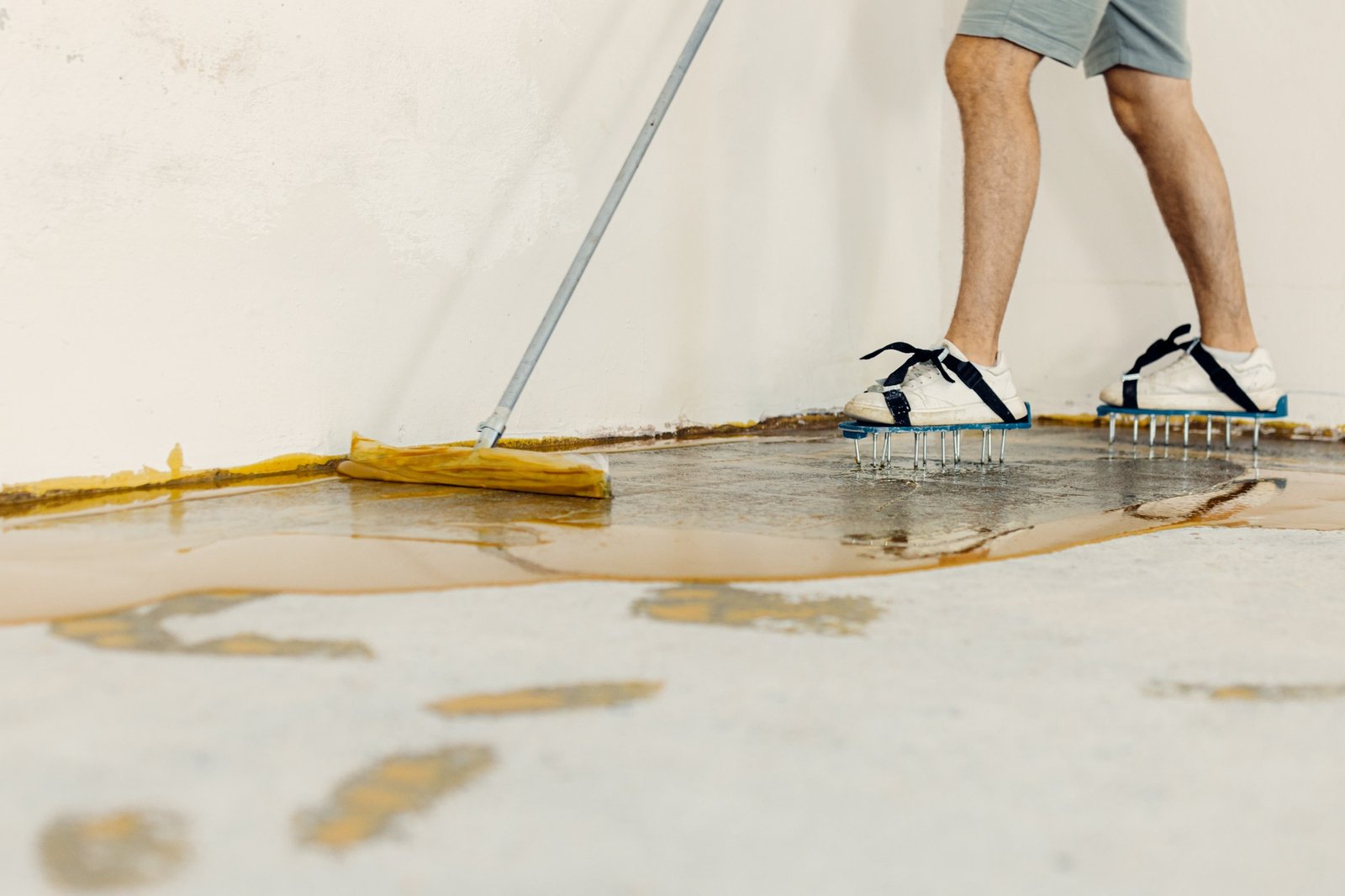 The worker applies yellow epoxy resin to the new floor
